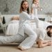 A cheerful family enjoys bonding and playing together on a cozy morning in a stylish bedroom.